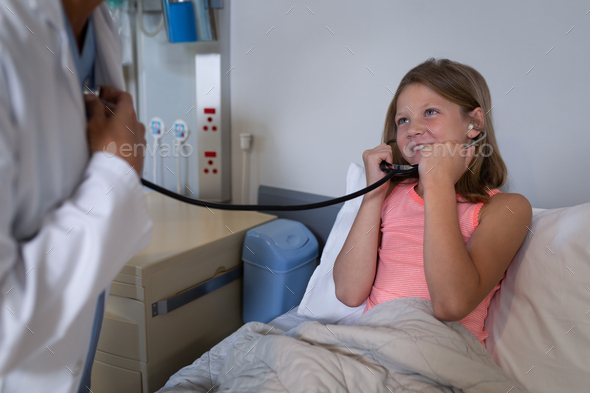 Patient listening to female doctors heart beat with stethoscope in hospital