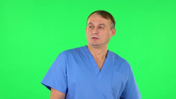 Medical Man Is Frightened, Then Sighs in Relief and Waves a Smile at Someone. Green Screen alt