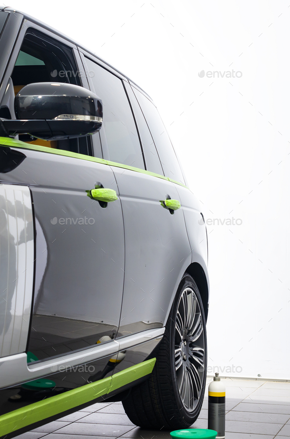 Car in applying green protective tape before polishing - Stock Photo - Images