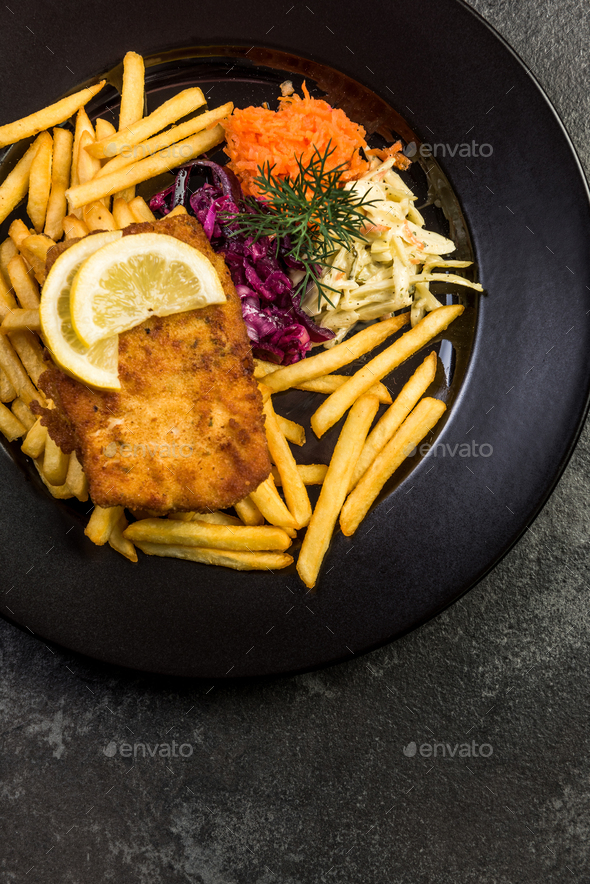 Pan fried fish with french fries and salad
