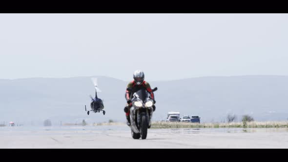 Motorcyclist and a Helicopter on a Strip