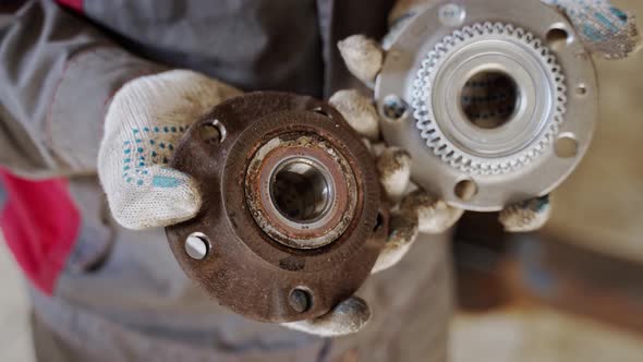 Master in White Gloves Holds in His Hands and Compares Old and New Automotive alt