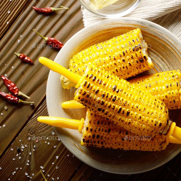 Top view of Wooden table with deep grilled sweet corn cobs under Stock
