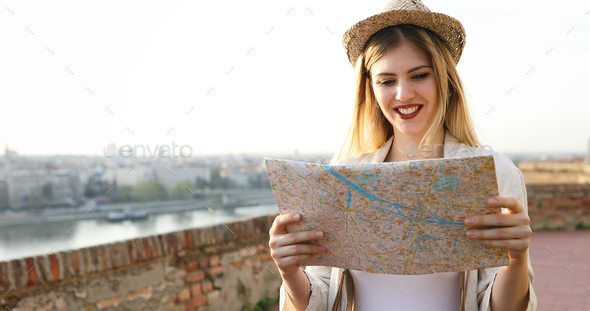 Tourist woman holding travelers map to travel to destination Stock Photo by nd3000