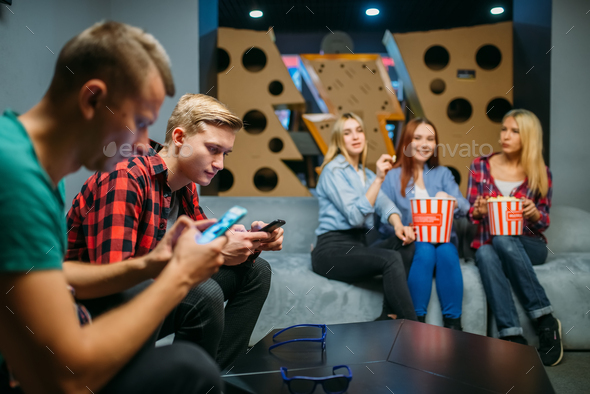Group of teenagers waiting for the film in cinema - Stock Photo - Images