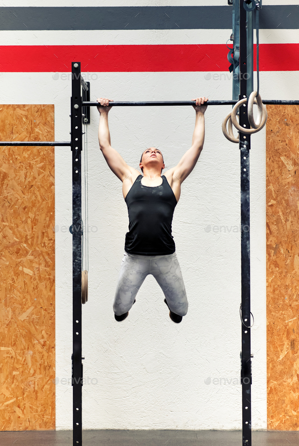 Young girl athlete doing pull-ups on a bar - Stock Photo - Images
