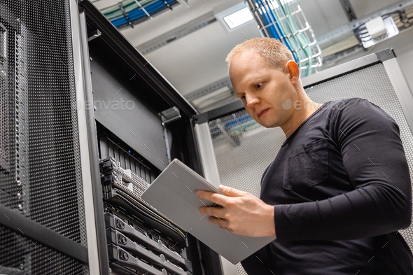 Male IT Professional Using Digital Tablet to Monitor Datacenter Status - Stock Photo - Images