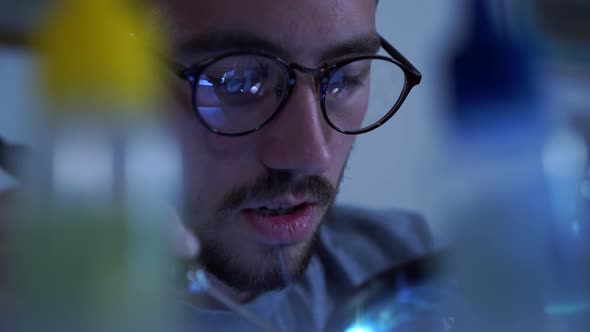 Portrait of Successful Young Bearded Man in Glasses Working with a Soldering Iron at His Working alt