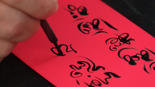 Vietnamese scholar writing calligraphy on the red envelope, ang pao in the lunar new year