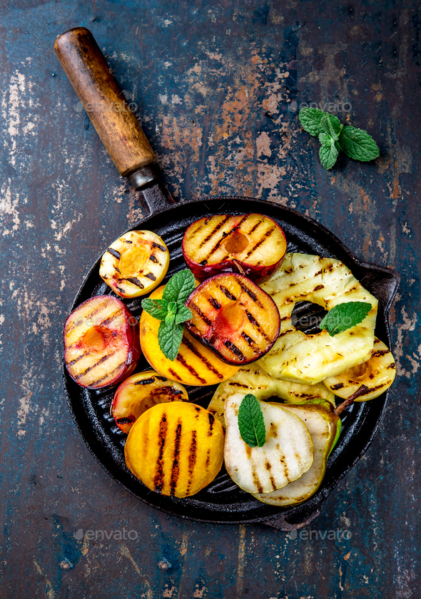 Grilled Fruits - Pineapple, peaches, plums, avocado pear on black cast iron grill pan