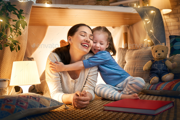 mother and daughter playing in tent - Stock Photo - Images