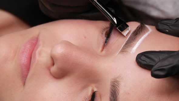 Master Applies White Markings to Correct Shape of Eyebrows with a Special Brush alt