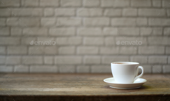White coffee mug on a wooden table And white brick background. Stock Photo  by poungsaed_eco