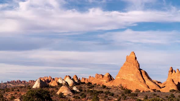 Timelapse looking past tall desert fins in Arches National Park alt