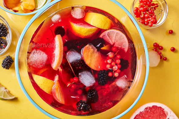 Top view on glass jug with homemade fruit berry drink with ice cubes on yellow background - Stock Photo - Images