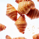 Falling fresh french croissants with crumbs on a light background - PhotoDune Item for Sale