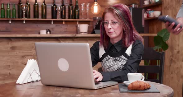Adult Woman Pays with NFC Payments in a Vintage Coffee Shop alt