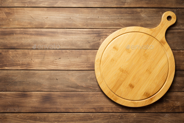 pizza cutting board at wooden plank board background Stock Photo by seregam