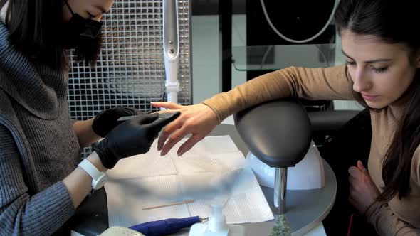 Manicurist in Face Mask and Gloves Creates Form of Nails alt