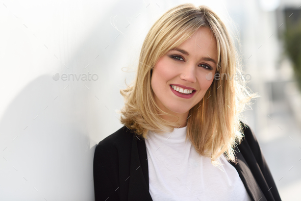 Beautiful young blonde woman in urban background - Stock Photo - Images