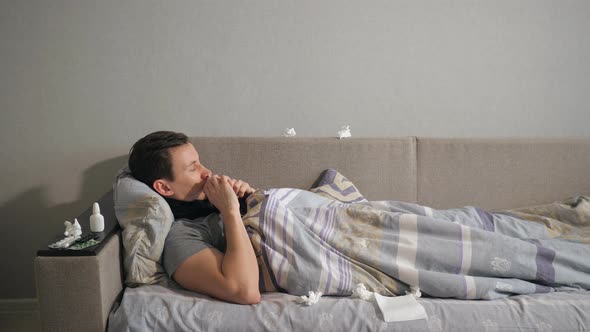 Sick Man Splashes a Medicine in the Nose While Lying on Couch at Home. alt