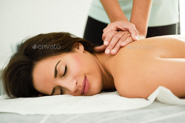 Young woman receiving a back massage in a spa center.
