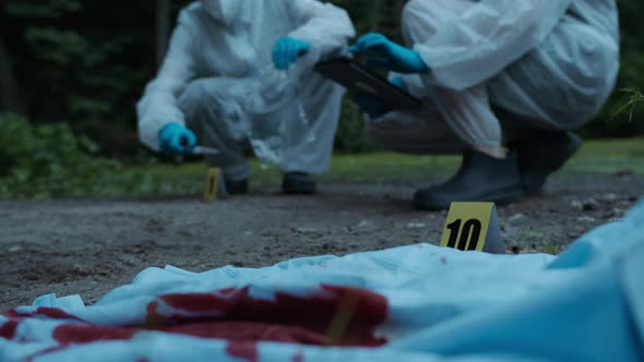Criminalists Discovering Knife at Crime Scene Closeup Taking Evidence From Accident Murder alt