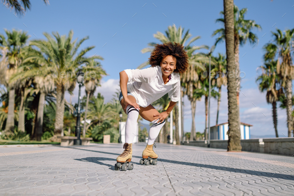 Black woman on roller skates rollerblading in beach promenade wi - Stock Photo - Images
