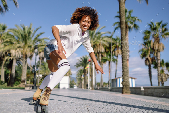 Black woman on roller skates rollerblading in beach promenade wi - Stock Photo - Images