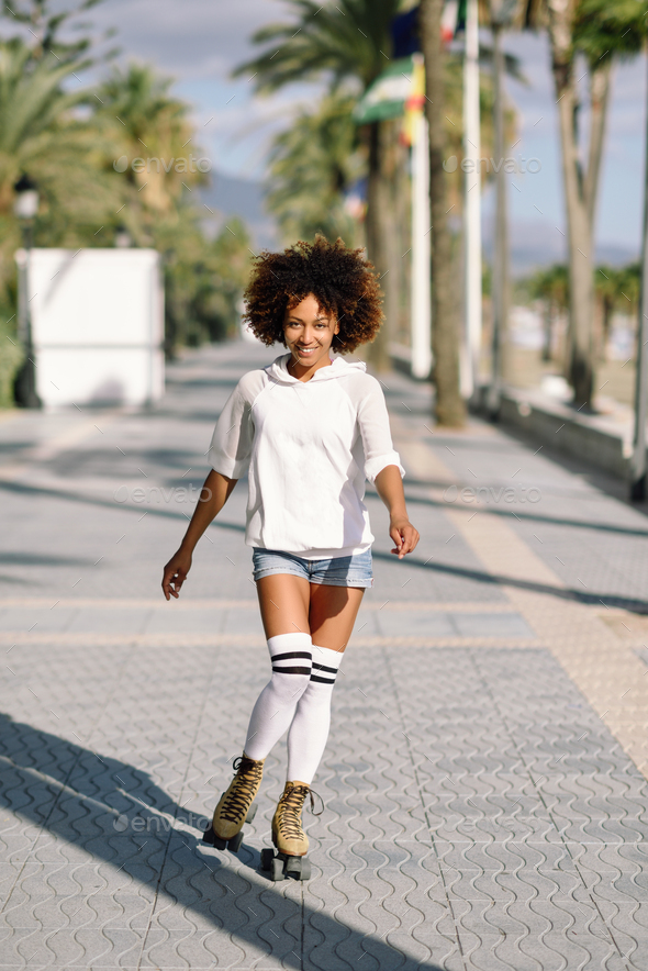 Black woman on roller skates rollerblading in beach promenade wi - Stock Photo - Images