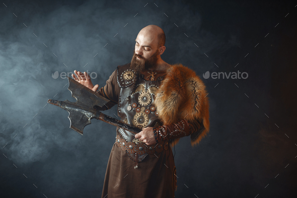 Bearded viking touches the axe blade