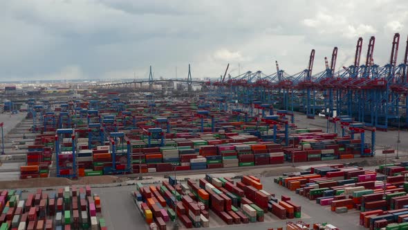 Aerial View of Many Automated Cranes Sorting and Placing Cargo Containers in Large Shipping Port in alt
