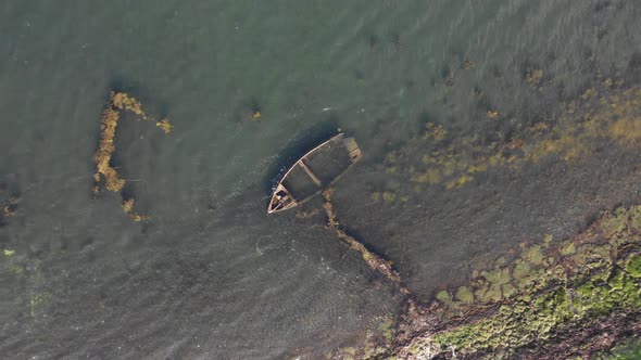 Aerial view of wrecked boats on the coast of Scotland on a sunny day