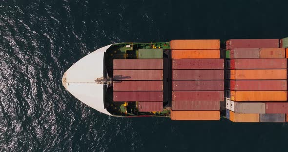 Shipping containers stacked on a sailing Container ship, Top down shot. alt