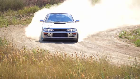 Sports Car With a Cloud of Dust on the Bend of the Rally Track