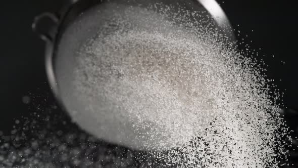 Dusting flour on black background. Slow Motion. alt