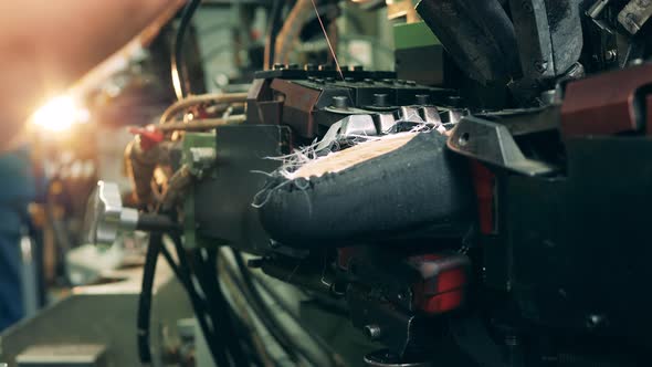 Mechanism Is Applying Glue To a Boot During Production alt