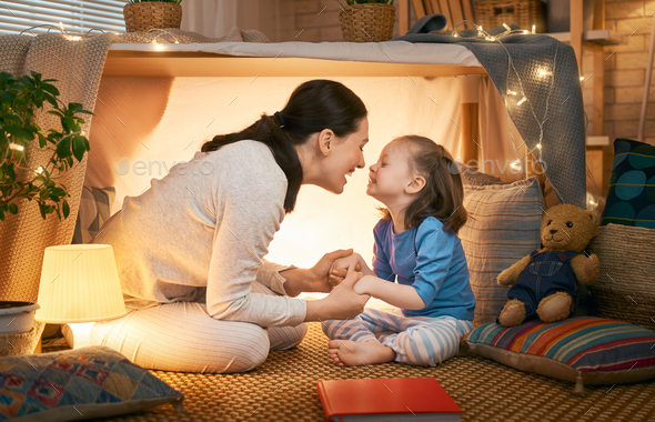 mother and daughter playing in tent - Stock Photo - Images