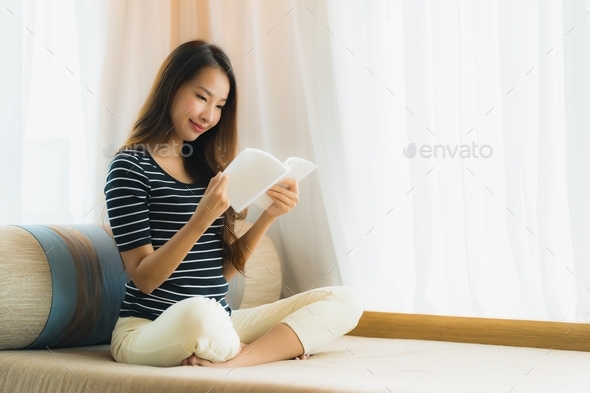 Portrait beautiful young asian woman reading book in on sofa in