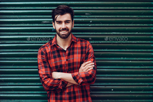 Young smiling man, model of fashion, wearing a plaid shirt with