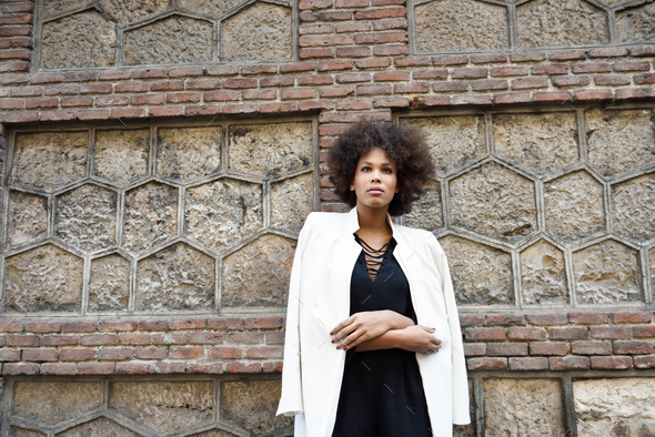 Young black woman with afro hairstyle standing in urban backgrou - Stock Photo - Images