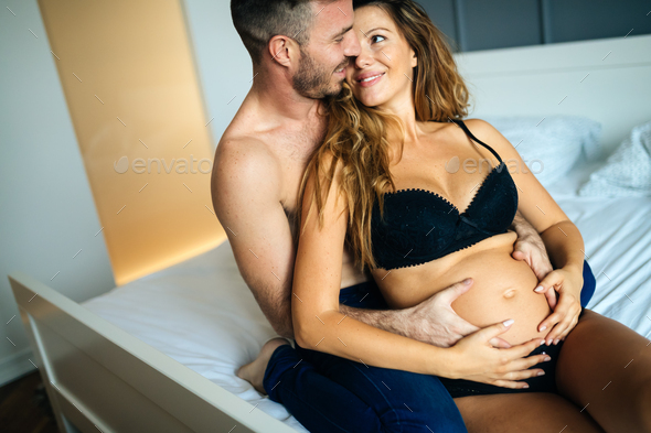 Happy Pregnant Woman Enjoying With Husband In Bedroom