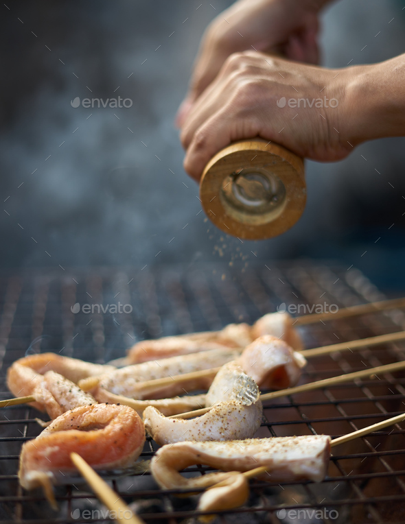 grinding the pepper on meat in grill