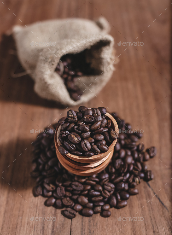 coffee beans on wood saucer and coffee bag