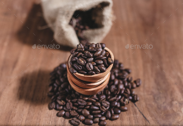 coffee beans on wood saucer and coffee bag