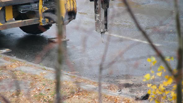 Tractor with hydraulic hammer ready for demolition work with asphalt pavement