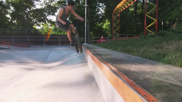 BMX Rider Doing Tricks in Cocncrete Skatepark Slow Motion alt