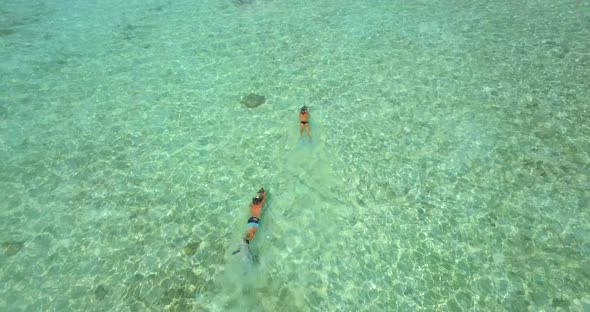 Aerial drone view of a man and woman couple snorkeling with seascooters alt