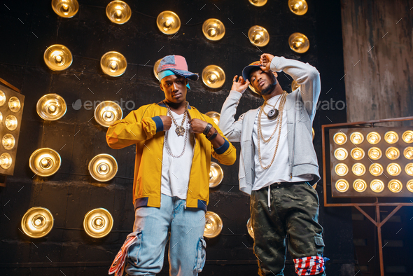 Black rappers in caps on stage with spotlights - Stock Photo - Images
