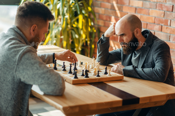 Male chess players, move the black elephant - Stock Photo - Images